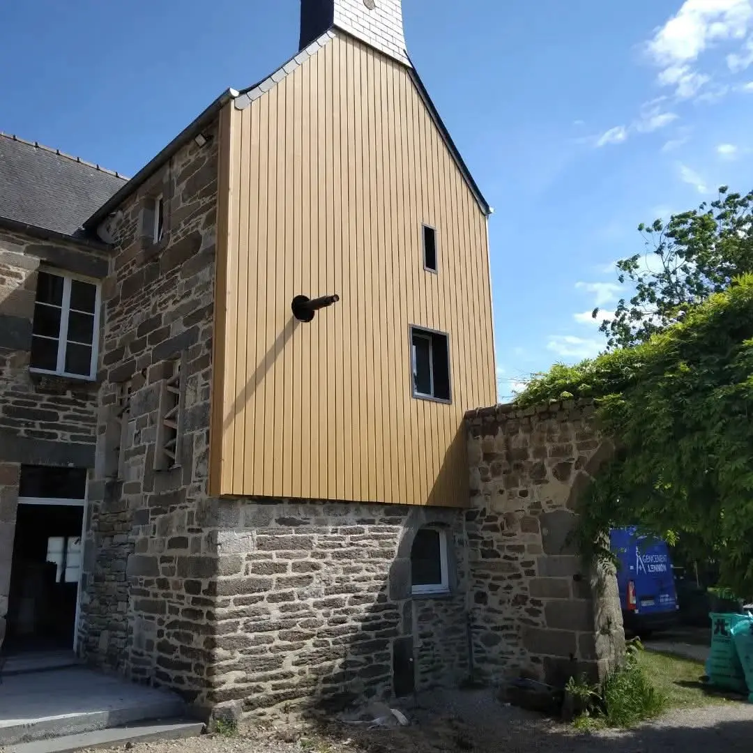 Travaux de rénovation de façade avec pose d'un bardage bois vertical sur une extension de maison à Landivisiau. réalisé par Agencement Lennon — Finistère